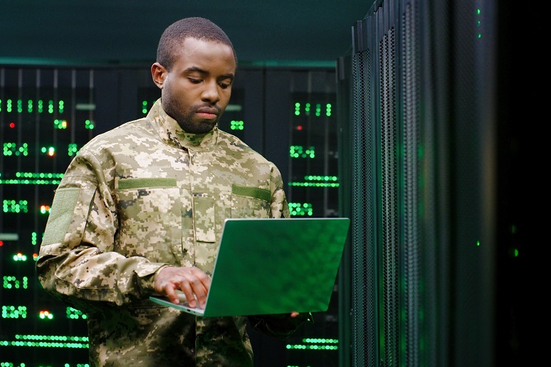 A military officer working on IT equipment