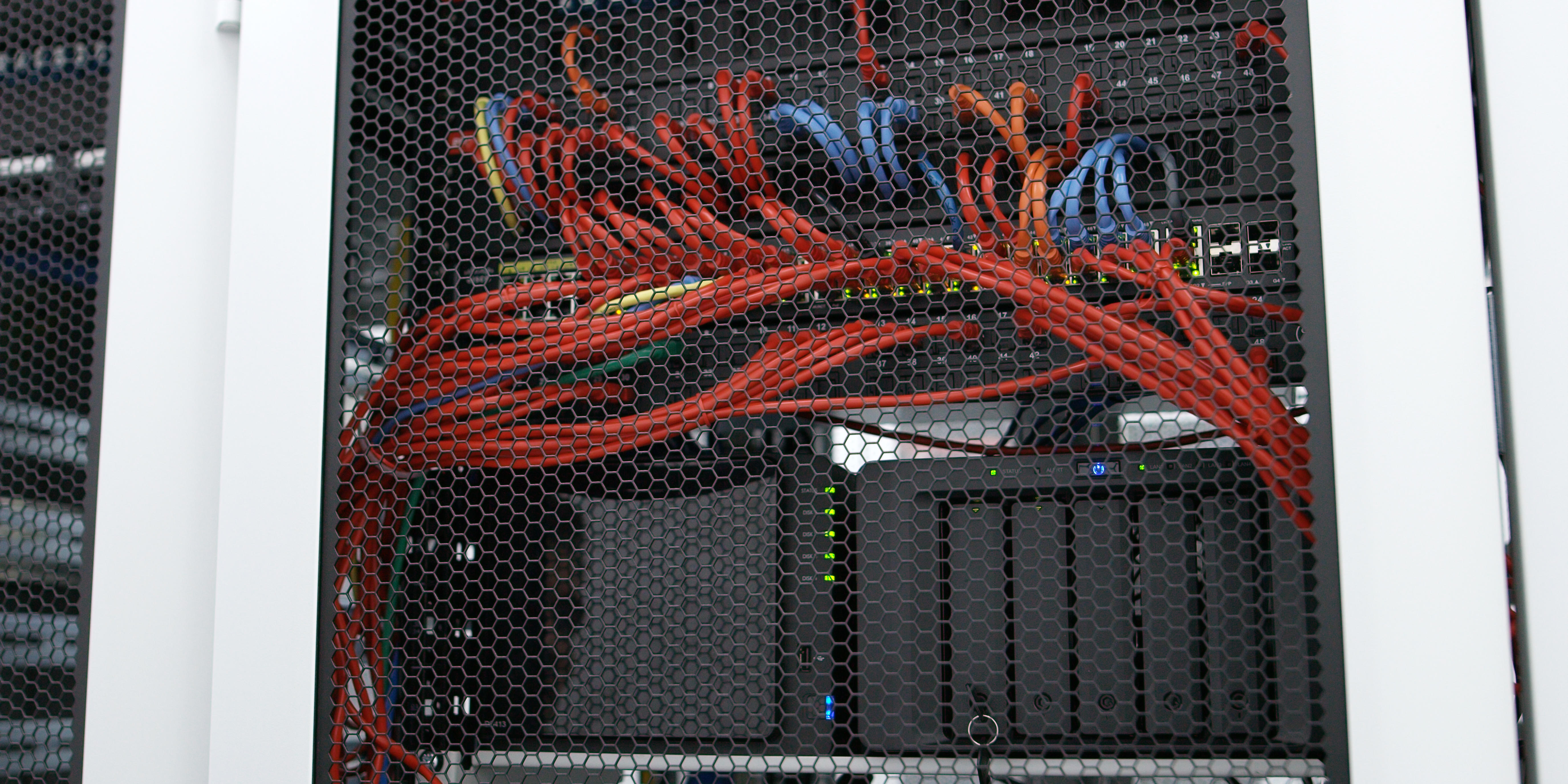 The back of a server and wires in a communications closet.