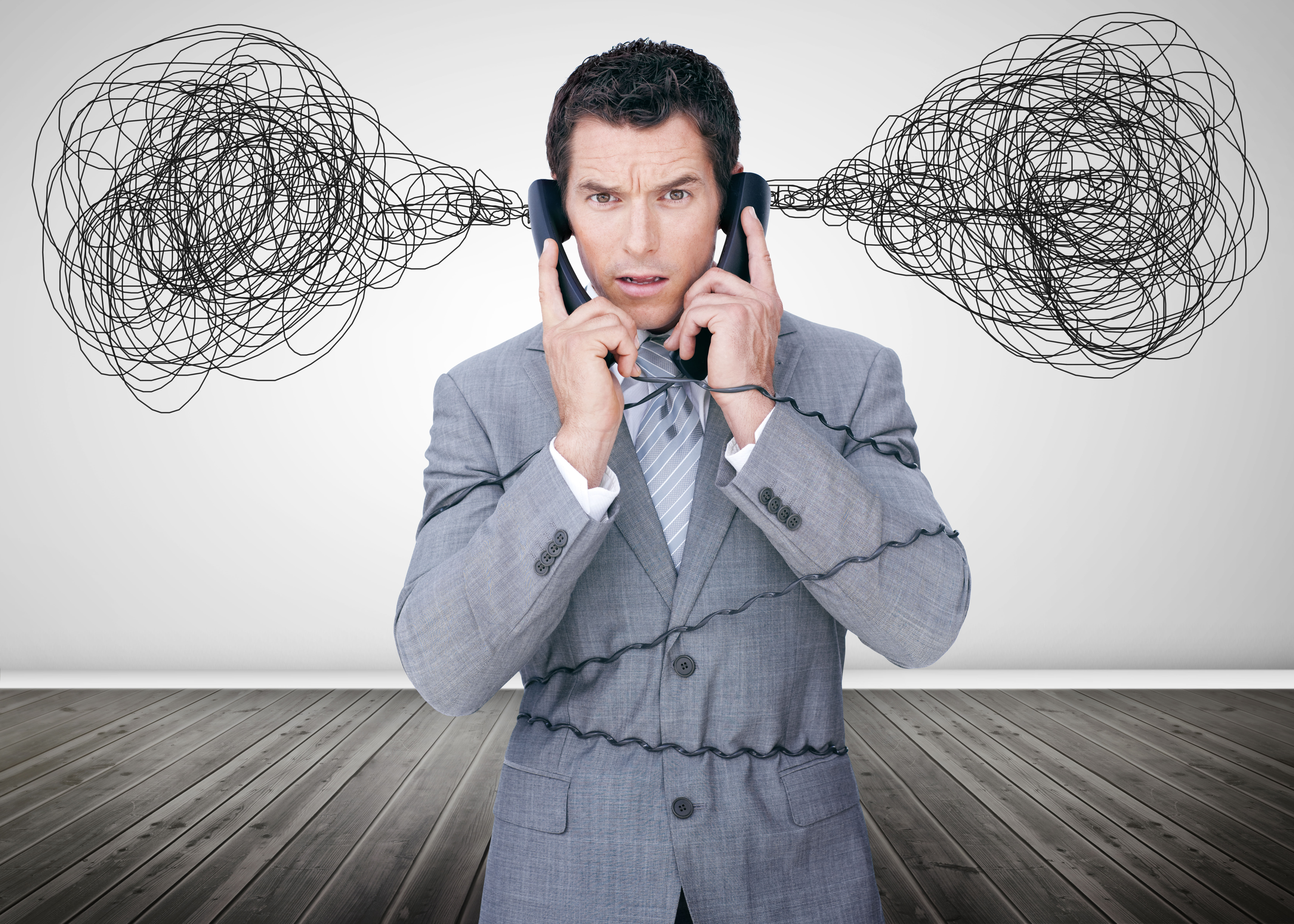 A man is listening to two separate phones and he has a cloud of confusion over his head