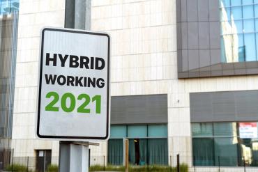 Photo of sign saying "hybrid work 2021" in front of office building