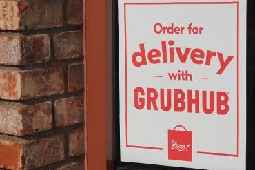 Photo of a restaurant door with a Grubhub sign