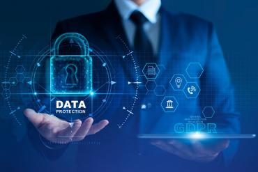 An image of a business man holding a data protection icon in one hand and GDPR in another
