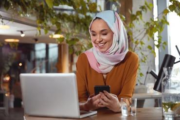 A woman with a hijab reading technology news