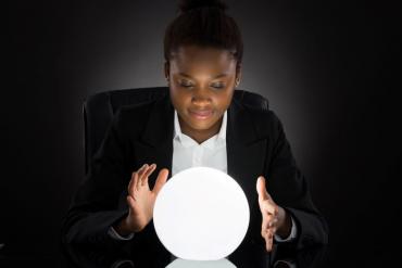 Young businesswoman looking into crystal ball