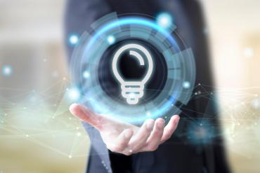 A business person holding a lightbulb icon