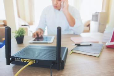 Someone working from home with a Wi-Fi router on the desk