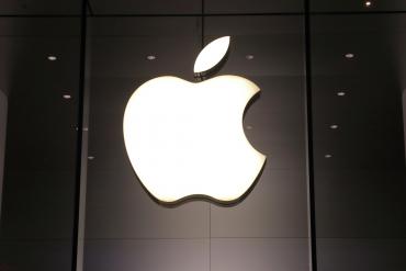A glowing Apple logo on a building's wall