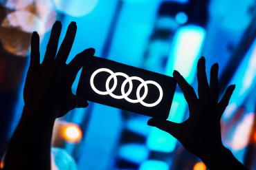 The Audi logo lit up on a smartphone.