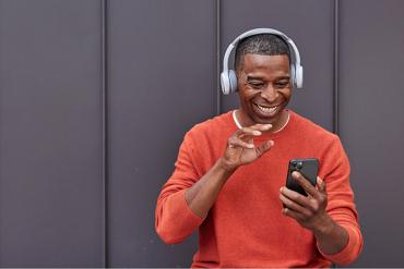 Smiling man touching a mobile phone