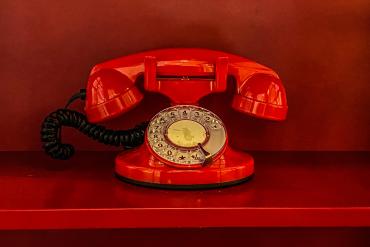 An old fashioned red landline phone.