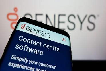 A photo of a phone in front of a laptop screen; both have Genesys Cloud screens