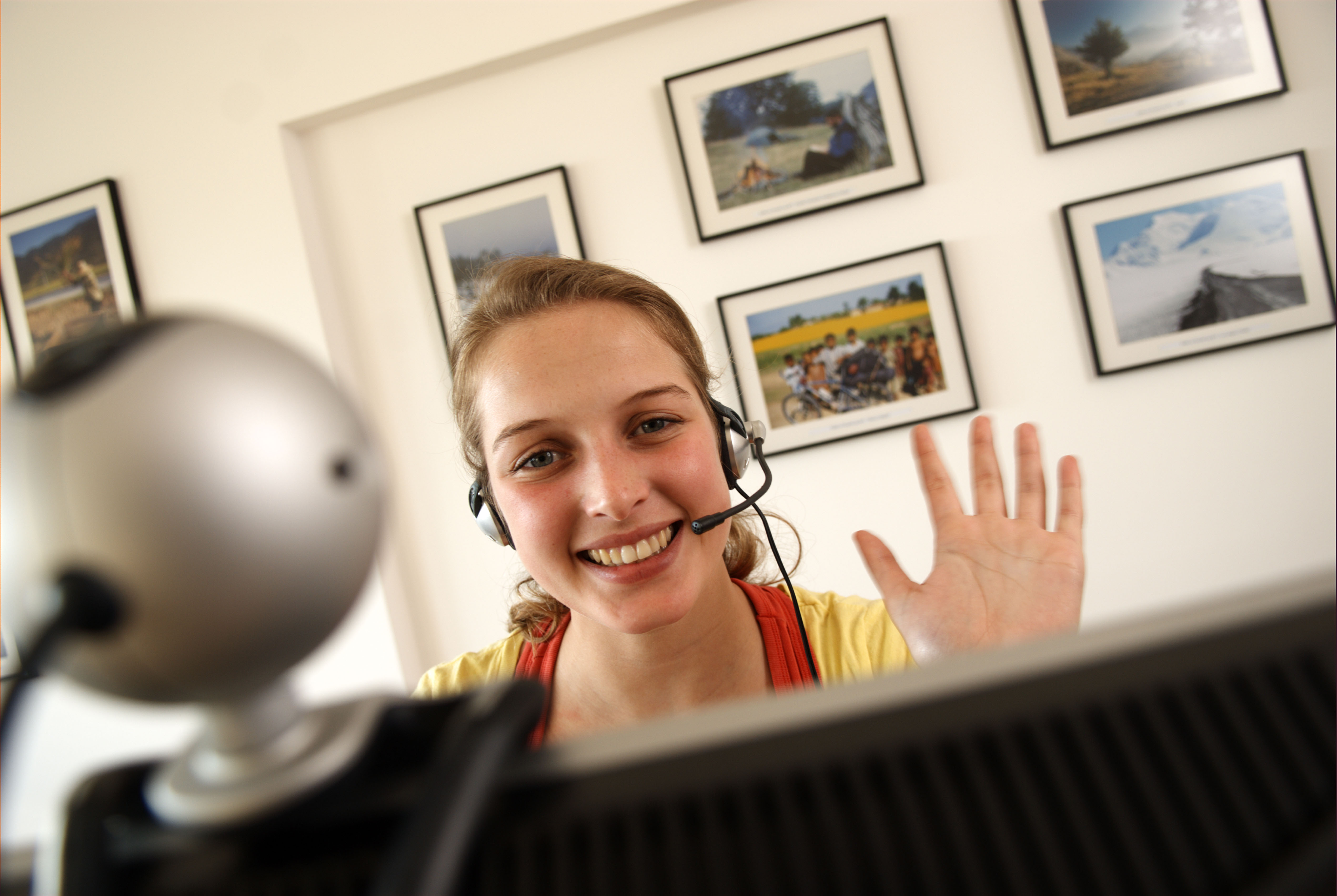 Image illustrating a woman waving at a webcam